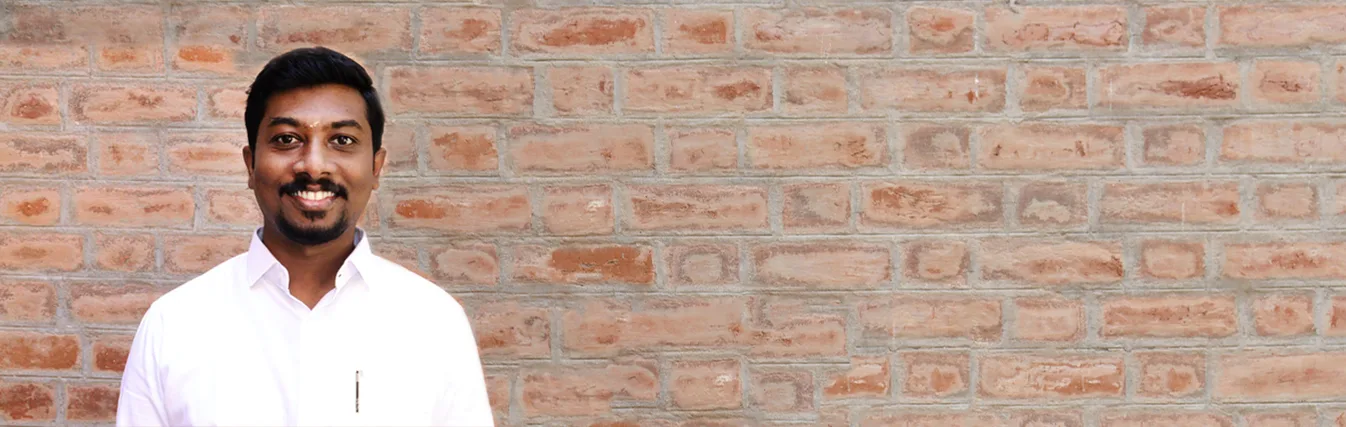 Man standing against a brick wall