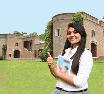 Student holding a book outside a heritage campus building