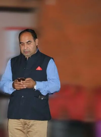 Man in a waistcoat holding a phone