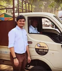 Portrait of Jay standing beside a delivery vehicle